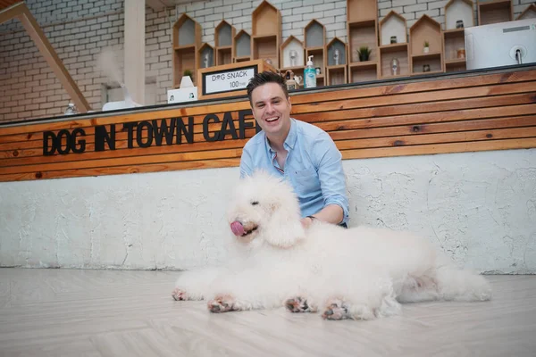 young man hugging his dog lying on floor.