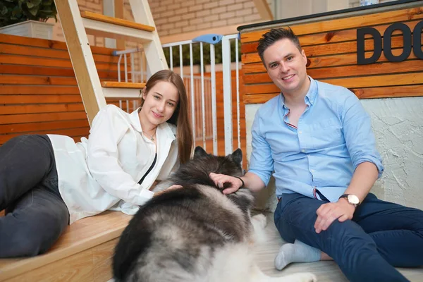 Man and girl with his pet dog playing on the floor. Happy dog, happy guy with dog.