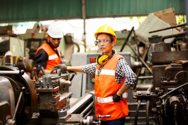 Fabrikada kaskı ve koruyucu üniforması olan işçi.
