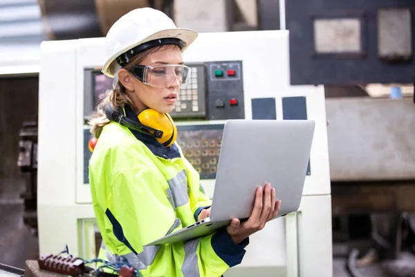 female engineer working with laptop in factory