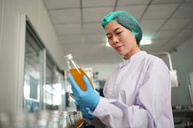 worker controlling the work of machine in production line at beverage industry.