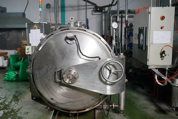 View of reservoires and soft drinks factory interior. worker controlling the work of machine in production line at beverage industry.