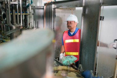 içecek endüstrisinde üretim hattını kontrol eden işçiler.