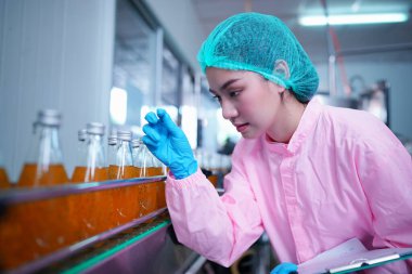 worker controlling the work of machine in production line at beverage industry.