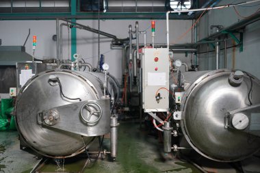 View of reservoires and soft drinks factory interior. worker controlling the work of machine in production line at beverage industry.