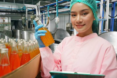 worker controlling the work of machine in production line at beverage industry.