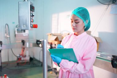 Asian worker labor working in food and beverage for drink industry factory with hygiene work fruit juice production line inspector staff. Inspect Beverage Process Check Production Line Conveyor