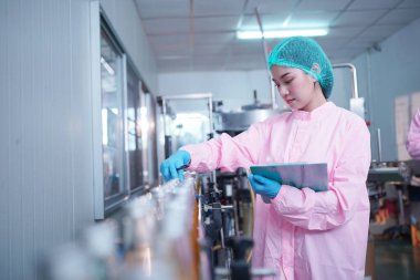 Asian worker labor working in food and beverage for drink industry factory with hygiene work fruit juice production line inspector staff. Inspect Beverage Process Check Production Line Conveyor