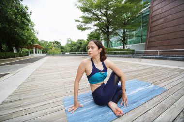 Young sporty attractive woman practicing yoga, doing yoga exercise, Beautiful young woman practicing yoga on wooden terrace.
