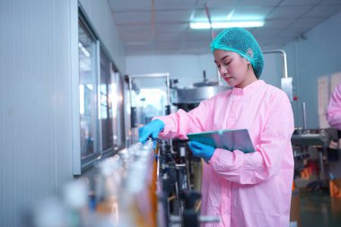 worker controlling the work of machine in production line at beverage industry.