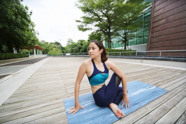 Young sporty attractive woman practicing yoga, doing yoga exercise, Beautiful young woman practicing yoga on wooden terrace.