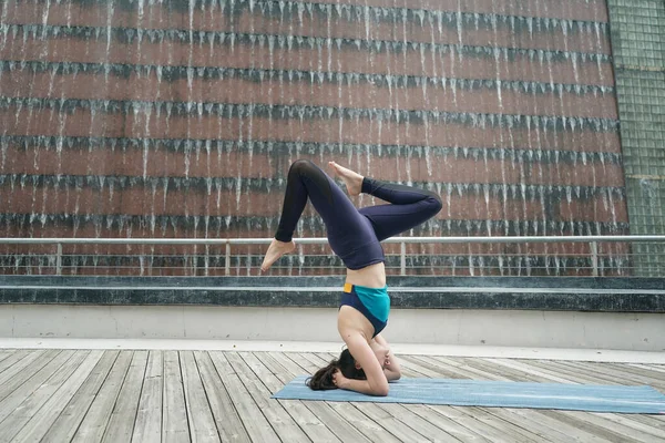 Young attractive woman doing stretching yoga exercise in the park.