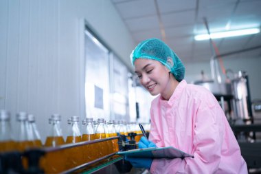Asian worker labor working in food and beverage for drink industry factory with hygiene work fruit juice production line inspector staff. Inspect Beverage Process Check Production Line Conveyor