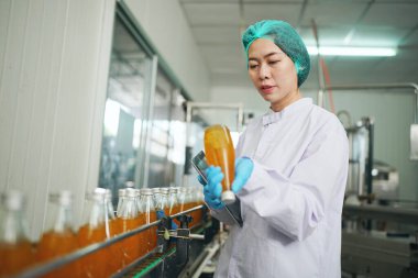 worker controlling the work of machine in production line at beverage industry.