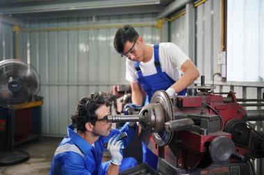 Workers changing and repair part of wheels at the car service