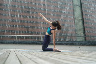 Young attractive woman doing stretching yoga exercise in the park.