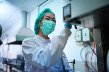 Asian worker labor working in food and beverage for drink industry factory with hygiene work fruit juice production line inspector staff. Inspect Beverage Process Check Production Line Conveyor