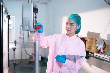 worker controlling the work of machine in production line at beverage industry.