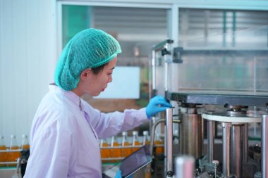 worker controlling the work of machine in production line at beverage industry.