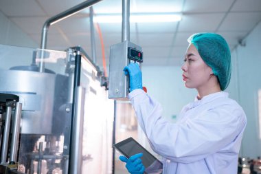 worker controlling the work of machine in production line at beverage industry.