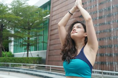 Young attractive woman doing stretching yoga exercise in the park.