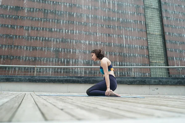 Young attractive woman doing stretching yoga exercise in the park.