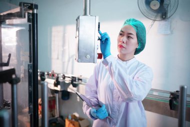 Asian worker labor working in food and beverage for drink industry factory with hygiene work fruit juice production line inspector staff. Inspect Beverage Process Check Production Line Conveyor