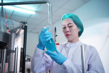 Asian worker labor working in food and beverage for drink industry factory with hygiene work fruit juice production line inspector staff. Inspect Beverage Process Check Production Line Conveyor