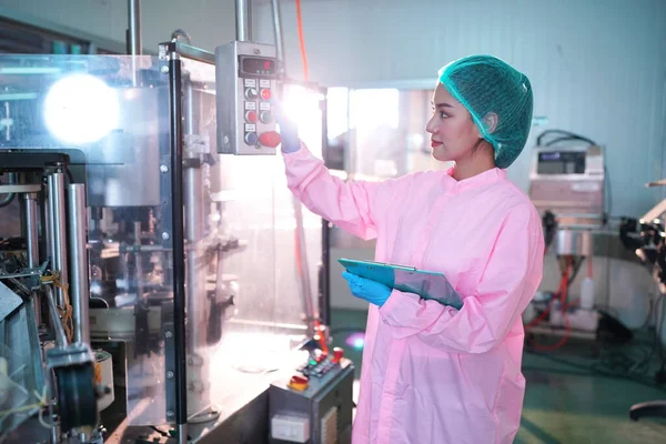 Asian worker labor working in food and beverage for drink industry factory with hygiene work fruit juice production line inspector staff. Inspect Beverage Process Check Production Line Conveyor