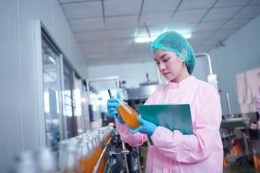 Asian worker labor working in food and beverage for drink industry factory with hygiene work fruit juice production line inspector staff. Inspect Beverage Process Check Production Line Conveyor