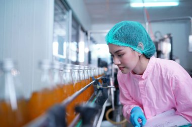 Asian worker labor working in food and beverage for drink industry factory with hygiene work fruit juice production line inspector staff. Inspect Beverage Process Check Production Line Conveyor