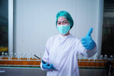 Asian worker labor working in food and beverage for drink industry factory with hygiene work fruit juice production line inspector staff. Inspect Beverage Process Check Production Line Conveyor