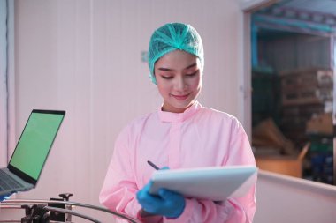 Asian worker labor working in food and beverage for drink industry factory with hygiene work fruit juice production line inspector staff. Inspect Beverage Process Check Production Line Conveyor