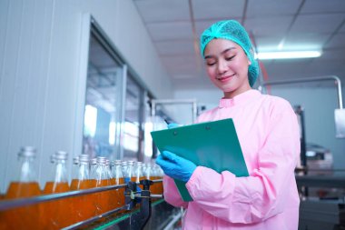 worker controlling the work of machine in production line at beverage industry.