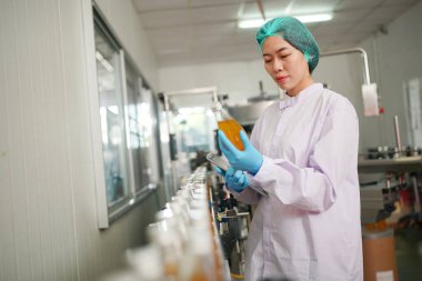 worker controlling the work of machine in production line at beverage industry.