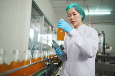worker controlling the work of machine in production line at beverage industry.