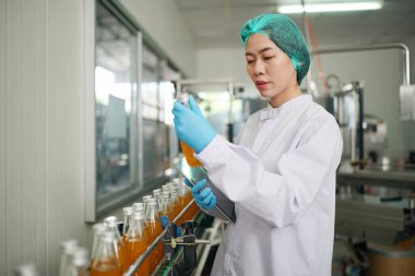 worker controlling the work of machine in production line at beverage industry.