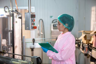 Asian worker labor working in food and beverage for drink industry factory with hygiene work fruit juice production line inspector staff. Inspect Beverage Process Check Production Line Conveyor