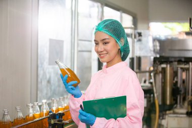 worker controlling the work of machine in production line at beverage industry.