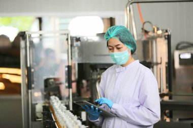 worker controlling the work of machine in production line at beverage industry.