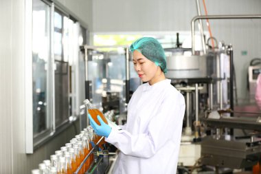 worker controlling the work of machine in production line at beverage industry.