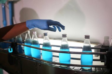 worker controlling the work of machine in production line at beverage industry.