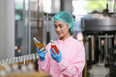 worker controlling the work of machine in production line at beverage industry.