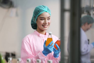 worker controlling the work of machine in production line at beverage industry.