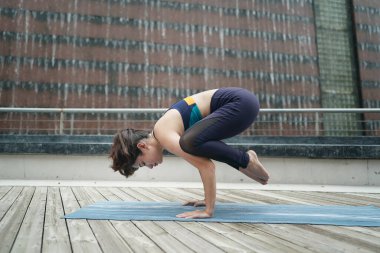 Young attractive woman doing stretching yoga exercise in the park.