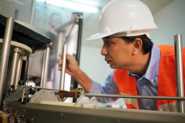 Asian worker labor working in food and beverage for drink industry factory with hygiene work fruit juice production line inspector staff. Inspect Beverage Process Check Production Line Conveyor