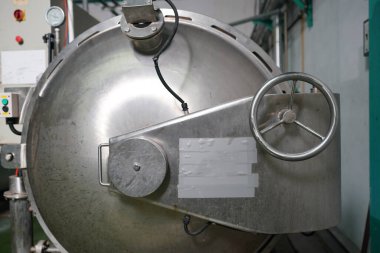 View of reservoires and soft drinks factory interior. worker controlling the work of machine in production line at beverage industry.
