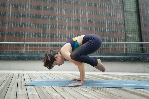 Young attractive woman doing stretching yoga exercise in the park.