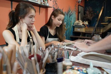 Kil vazolar ve çömlekçilik üzerine çalışan esnaf kadınlar, iş sahipleri.