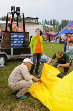 İnsanlar şehir parkında sıcak hava balonu hazırlıyorlar.